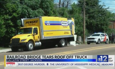 Railroad bridge in Jackson tears roof off truck