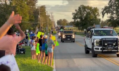 Community lines up with signs to thank parade of lineworkers