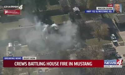 Firefighters battle house fire in Mustang